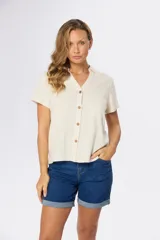 Camisa color crema de lino con viscosa, corte recto, cuello camisero, mangas cortas y botones de madera.