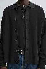 Cárdigan negro de punto con cuello solapa, manga larga y cierre frontal con botones.