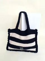 Bolso tipo tote tejido a crochet, con hilo 100% algodón, a rayas horizontales color crema y lila, con volados en los bordes y manijas reforzadas.
