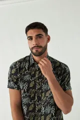 Camisa de hombre estampada, de manga corta y fit slim. Presenta cartera abotonada y logo bordado.