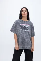 Remera gris con efecto marmolado, calce boxy, diseño fotográfico y texto en el frente.