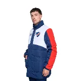 Campera larga acolchada Umbro Heritage del Club Nacional de Football, con diseño en bloques de color azul, blanco y rojo. Presenta cuello alto, cierre frontal con botones a presión, bolsillos laterales y escudo del club bordado en el pecho.