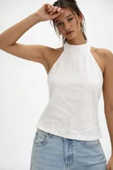 Musculosa color ladrillo de tejido de punto, con cuello halter y espalda descubierta.