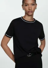 Camiseta negra de algodón con cuello redondo y ribetes blancos en cuello y mangas. Corte recto y manga corta.