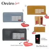Billetera negra de cuero sintético con cierre, estampado con la palabra "LOVE" repetida en el frente y dije colgante en forma de corazón rojo con la inscripción "OREIRO LOVE".