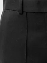 Pantalón de vestir negro con corte ajustado y detalles de pinzas.