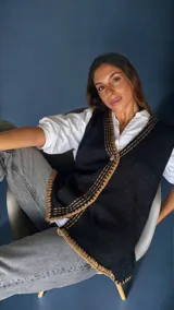 Chaleco tejido a mano con escote en V, bordado con botones, confeccionado en algodón con detalles de lurex. Terminaciones en crochet y bordados hechos a mano con lana merino.