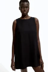 Vestido corto negro sin mangas, de corte evasé, con escote redondo, abertura de cerradura con botón oculto en la nuca y bajo recto. Parcialmente forrado.