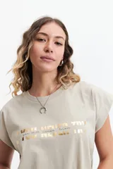 Musculosa oversize color beige con estampado dorado que dice "If you never try you will never know".