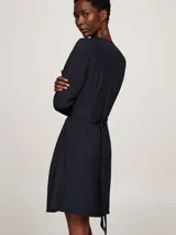 Vestido corto azul marino de viscosa, con escote en V, mangas largas y cierre cruzado con doble botonadura dorada.