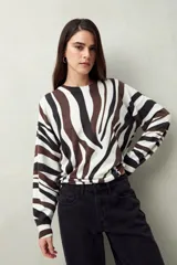 Sweater de punto liviano con estampado animal print estilizado en tonos neutros. De silueta relajada y tejido suave al tacto.