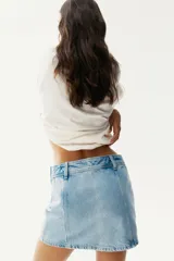 Minifalda de jean celeste, de corte evasé, con cintura alta y cierre lateral oculto.