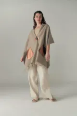 Chal de lana fina sin teñir, con calce en hombros, abrochadura con alamar de fieltro, bolsillos de cuero y terminación con flecos. Diseño exclusivo de Don Baez, hecho en Uruguay.