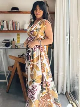 Vestido largo con estampado de hojas en tonos marrones, amarillos y verdes. Tiene escote cruzado y cinturón de la misma tela.