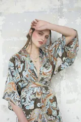 Kimono largo con estampado paisley en tonos marrones, celestes y naranjas. Tiene mangas 3/4 amplias y corte cruzado con lazo en la cintura.