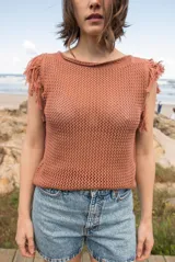 Musculosa color ladrillo de tejido calado con flecos en los hombros y cuello redondo.