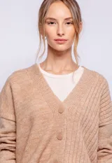 Cardigan de punto color verde, con botones a tono y diseño de canaletas en uno de sus lados.