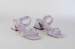 Sandalias de tacón fucsia con dos tiras con tachas piramidales y tacón cuadrado.