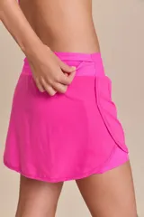 Pollera deportiva color verde lima, con short interno y bolsillo en la cintura.