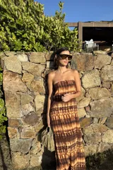 Vestido strapless largo con estampado batik en tonos marrones y beige, entallado al cuerpo y con espalda baja descubierta.