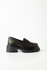 Mocasines de cuero marrón con suela track y detalle de antifaz.