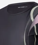 Remera deportiva femenina de manga corta, color negro, confeccionada en microfibra de helanca. Posee escote redondo y estampado localizado en formato de ondas en el lateral delantero en tonos verde, lila y rosado.