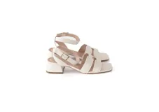 Sandalias de cuero color crema con taco cuadrado bajo y pulsera al tobillo con hebilla dorada.