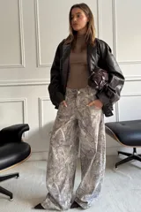 Pantalón baggy gris con estampado abstracto en tonos beige y blanco.