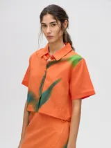 Falda midi marrón con estampado floral en tonos lila, abertura lateral y tiras ajustables.