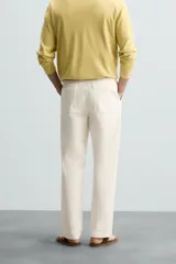 Pantalón chino color crema, de corte recto y largo a la altura del tobillo.