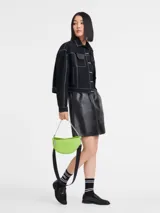 Bandolera Longchamp modelo Crossbody Smile S, color verde lima, con correa de cadena plateada y correa de tela negra con logo de la marca.