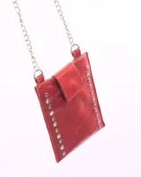 Bandolera porta celular roja de cuero con cadena plateada. Tiene bolsillo interior con cierre y forro.