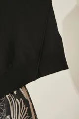 Sweater negro oversize de tejido de punto, con cuello alto y detalle de costuras a la vista.
