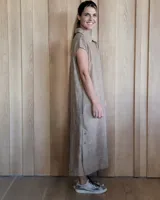 Túnica celeste de corte recto, con cuello camisero, mangas cortas, tajos laterales y cierre frontal con botones.