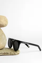 Lentes de sol con montura redonda de acetato color beige translúcido y lentes marrones.