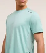 Remera deportiva gris con cuello redondo, mangas cortas, estampa heat print y detalle en los hombros. Confeccionada en tejido de malla con tecnología Dry.