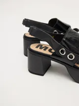 Sandalias negras de cuero con plataforma y taco ancho. Tienen correa trasera con elástico y doble argolla en la parte externa e interna.
