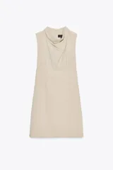 Vestido corto color beige, sin mangas y con cuello drapeado.