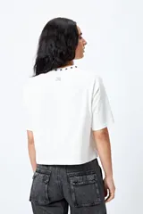 Remera negra de corte holgado con mangas ranglan y cuello redondo con bordado de estrellas blancas.