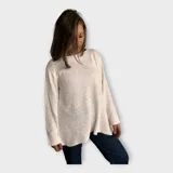 Sweater tejido color crudo, con escote redondo y hebra en relieve con brillo.