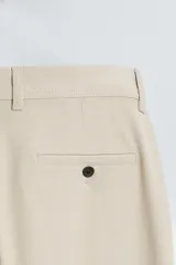 Pantalón de vestir gris oscuro, corte slim fit, con bolsillos laterales y traseros con botón.