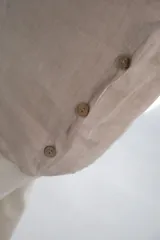 Blusa color crudo de lino, con cuello redondo y mangas cortas.