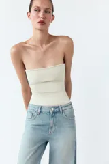 Pantalón de jean de tiro medio con cinco bolsillos, corte wide leg y detalle de tejido con lavado lateral combinado. Cierre frontal con cremallera y botón.