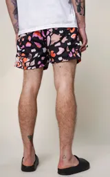 Short de baño de microfibra con estampado abstracto en tonos tierra, naranja, lila y blanco sobre fondo negro. Presenta cintura elástica con cordón ajustable y un bolsillo trasero con ojalillo.