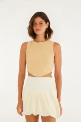 Top color beige, corte crop, con escote redondo y tirantes anchos.