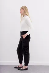 Pantalón babucha verde esmeralda de terciopelo con elástico en la botamanga, bolsillos plaqué en el frente con remaches metálicos y bolsillos cargo en las piernas.