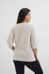 Sweater color beige de tejido de punto, con escote en V y mangas 3/4.