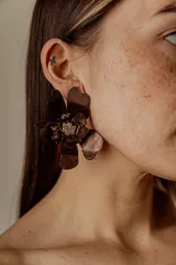 Aros colgantes con forma de flor color bronce y centro con apliques de strass.