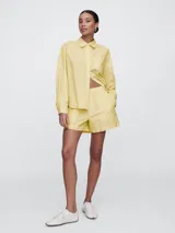 Short amarillo con finas rayas verticales negras, de corte holgado y cintura elástica.