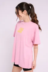 Remera oversize color rosado con estampado gráfico en el frente que dice 'Chill More'.